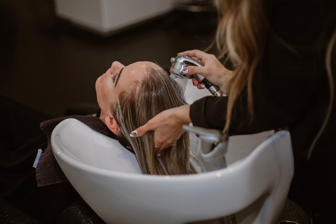 Estilista atendiendo a una clienta en un salón de belleza